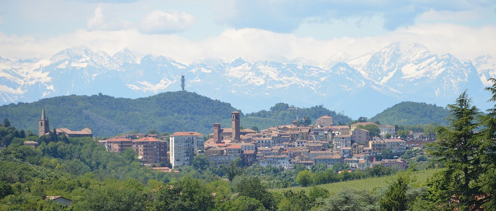 Il profilo di Moncalvo sulla collina, visto da Grazzano Badoglio, con le Alpi innevate sullo sfondo