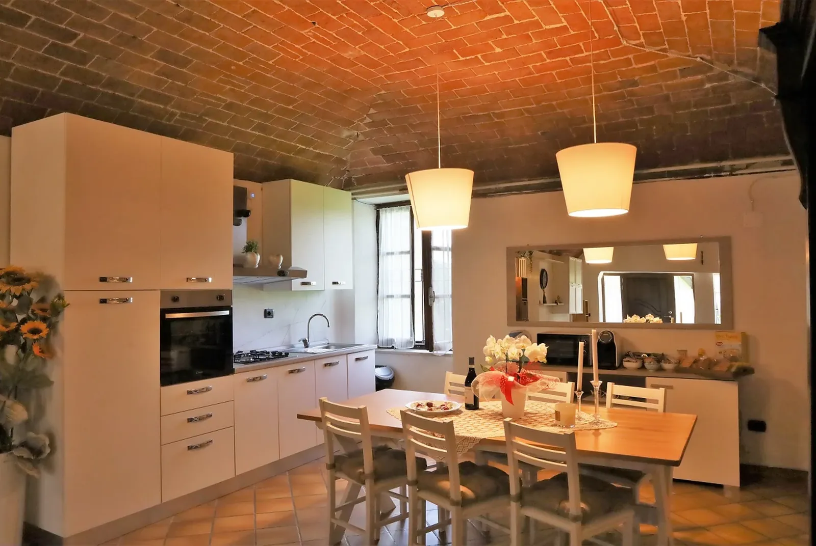 La cucina aperta con il lungo tavolo da pranzo
